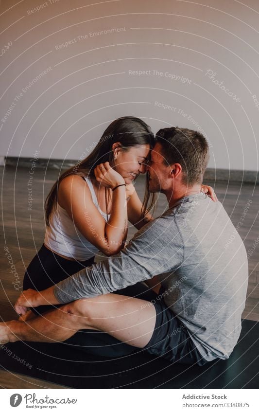Delighted couple embracing while relaxing together after training in spacious modern gym embrace love athlete studio enjoy lounge happy relationship girlfriend