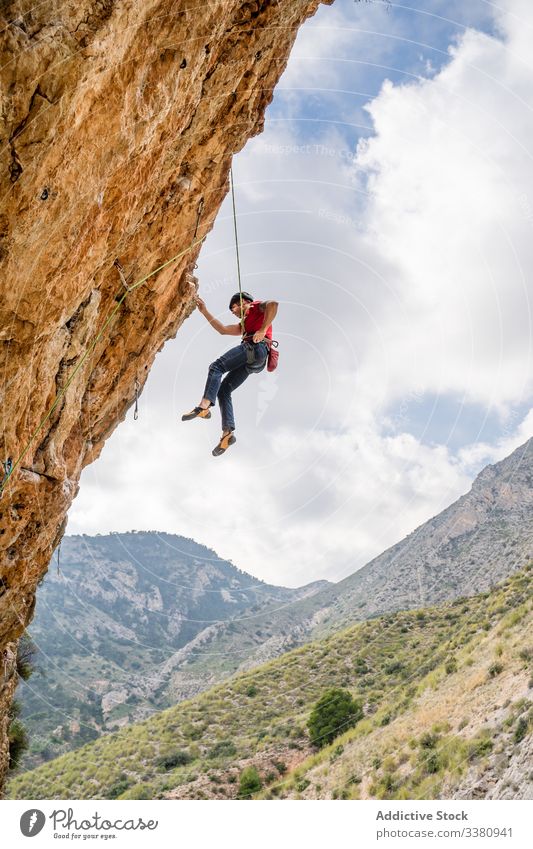 Courageous female climber hanging on cliff - a Royalty Free Stock Photo  from Photocase