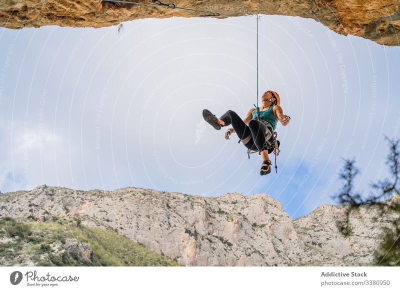 Female climber enjoying mountaineering woman alpinist hang cliff ascend terrain female adventure extreme risk active challenge adrenalin freedom altitude rope