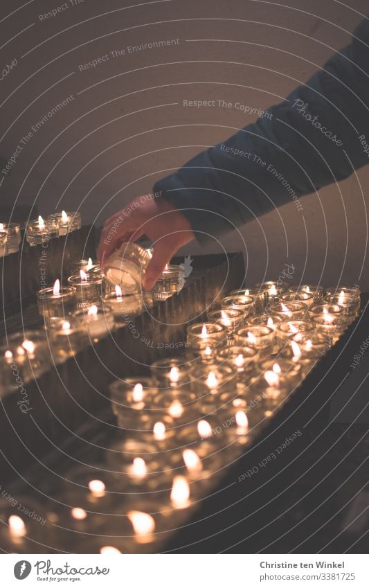 Woman lighting a candle at a candle altar candles Feminine Religion and faith Sadness Hope Belief Adults Hand 1 Human being 30 - 45 years Candle altar