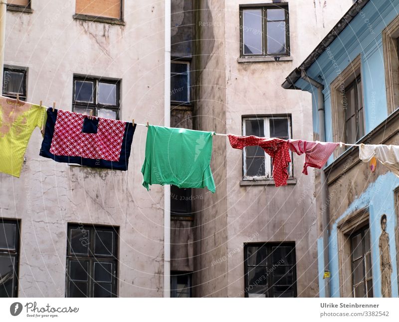 Coloured laundry on a line in the backyard of the Gängeviertel in Hamburg Laundry clothesline Dry corridor district Backyard Old building Gloomy colored