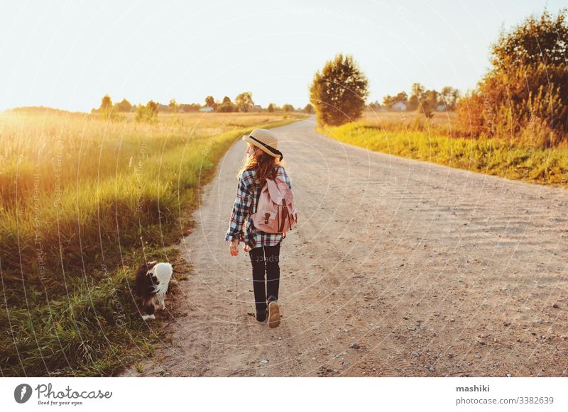 happy child girl walking country road with her dog. Enjoying summer vacations, rural living concept nature outdoor friend freedom lifestyle fun travel adventure
