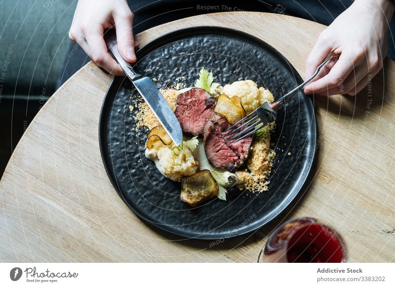 Person having roast beef with vegetables for meal chip dinner eat slice gastronomy cauliflower cutlery restaurant cream sauce garnish portion plate fresh