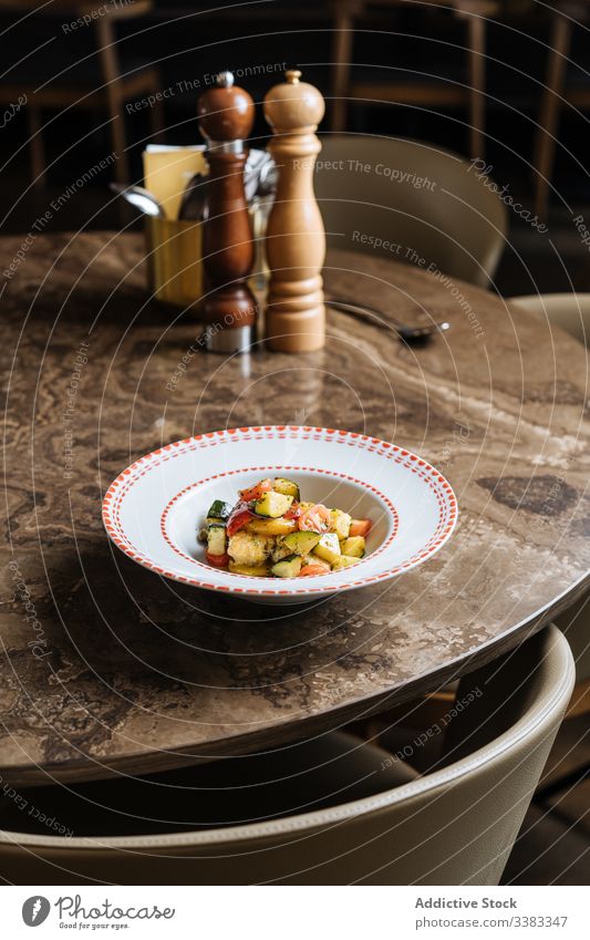 Vegetable salad in white plate on marble table in restaurant vegetable tomato cauliflower green vegan culinary herb food tasty delicious dish lunch dinner