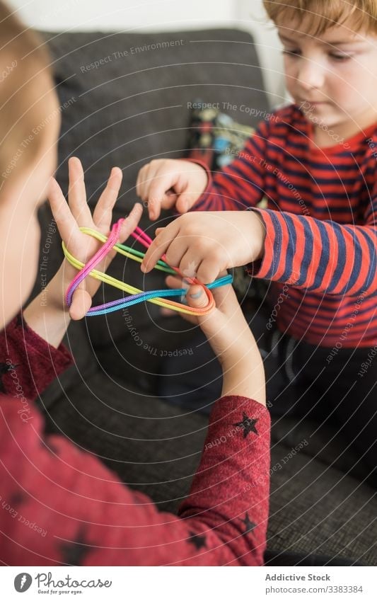 Smart children using rubber bands for game creative colorful learn upbringing kid play elastic together little palm twist casual home fun holiday rest relax