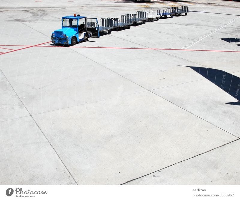 Baggage trolley without luggage at the airport at the parking position of a shadow-throwing aircraft Airport Luggage baggage car Transport Tractor Trailer