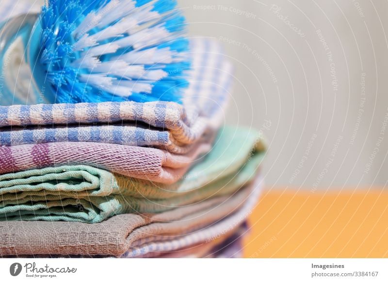 https://www.photocase.com/photos/3384167-dishcloths-and-dish-brush-on-yellow-background-linen-and-cotton-cloths-stack-of-coloured-tea-towels-photocase-stock-photo-large.jpeg