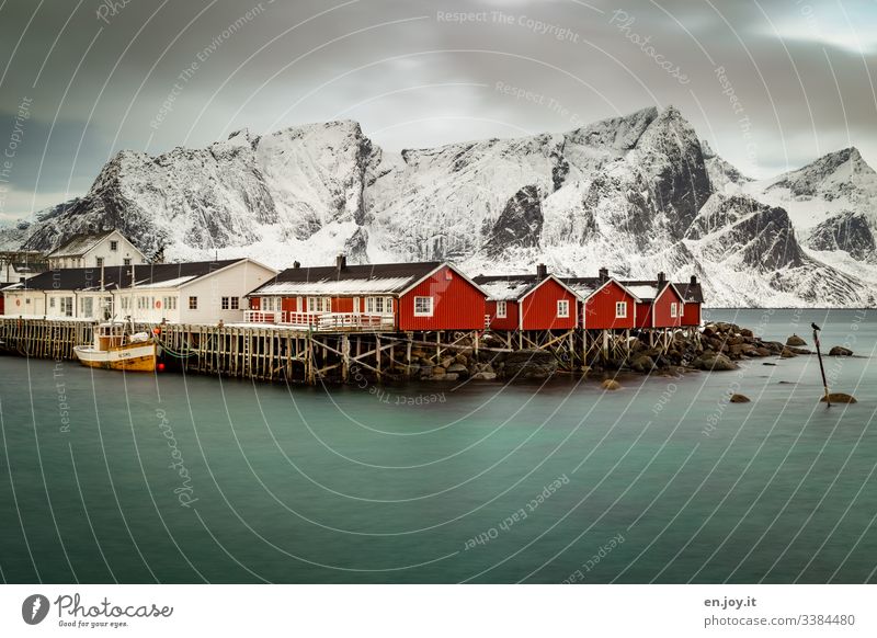 Fishing huts by the fjord in front of snowy mountains Vacation & Travel Trip Winter Snow Winter vacation Environment Landscape Sky Clouds Bad weather Wind Ice
