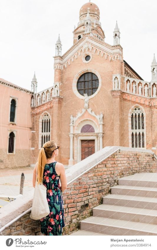 Young female traveler looking at the church in Venice, Italy ancient architecture attraction beautiful bridge building casual city cityscape culture day
