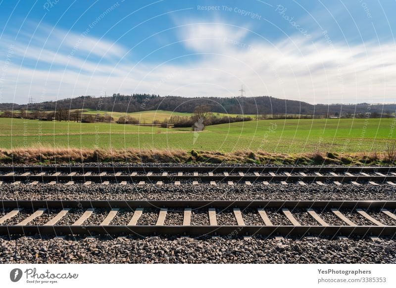 Railway tracks and sunny spring nature scenery. Railroad tracks Germany blue sky direction european railway forest german railroad gravel green fields hills