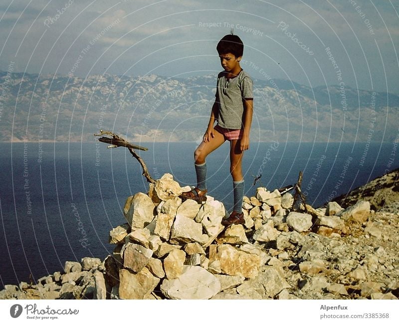 Young attractive child climbs a mountain with a stick in underpants Mountain Mountain range Mountain ridge Boy (child) Blue Hiking Mountaineering Nature