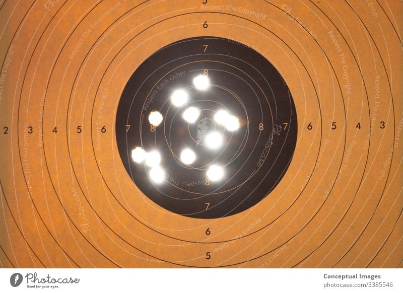 Close up of a shooting target with backlit bullet holes accuracy accuracy concept accurate aim aiming air army bullseye center close up competition competitive