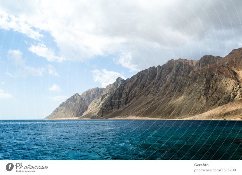 blue sea and high rocky mountains against the sky and clouds in Egypt Dahab South Sinai Middle East Near East Red Sea background day horizon landscape