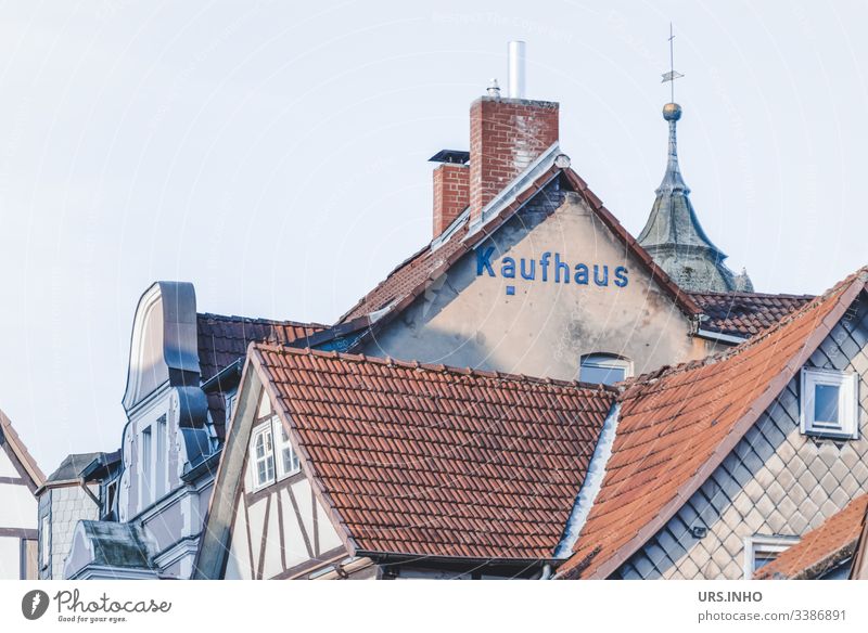 Roofs of old half-timbered houses and gables with the inscription Kaufhaus roofs Brick Half-timbered house Spire chimneys Village Old town Subdued colour