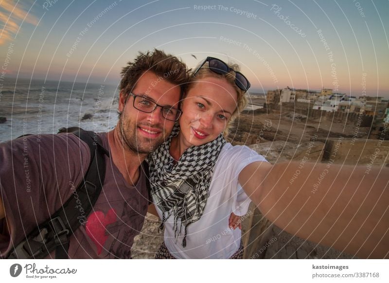Traveler couple taking selfie on city fortress wall of Essaouira, Morocco. traveler adventure explorer people journey lifestyle freedom outdoor tourism young