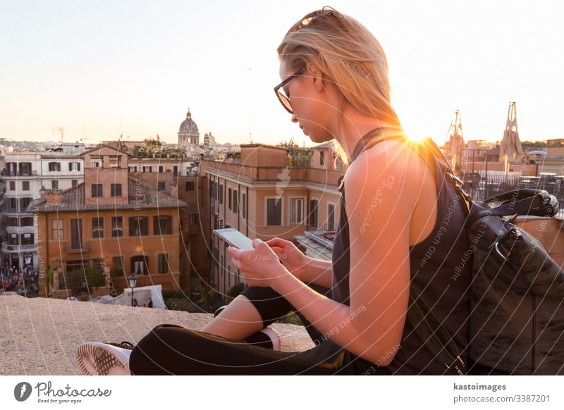 Female tourist using mobile phone travel app close to Piazza di Spagna, landmark square with Spanish steps in Rome, Italy at sunset. rome Spanish square woman
