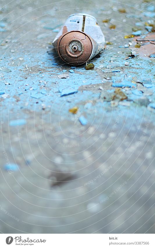 alt l old, blue, cracked, empty spray can, lies on morbid, flaked, broken blue background Environmental sin, pollution, garbage, scrap by carelessly, irresponsibly thrown away paint can in Lost Place. Non-degradable scrap metal.