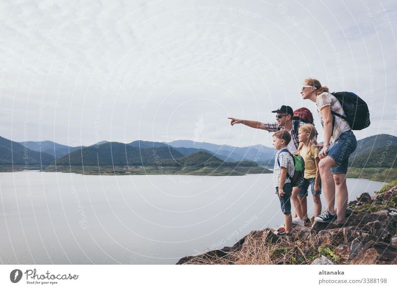 Happy family standing near the lake at the day time. outdoor travel child people son lifestyle vacation boy nature father together active summer dad kid trip