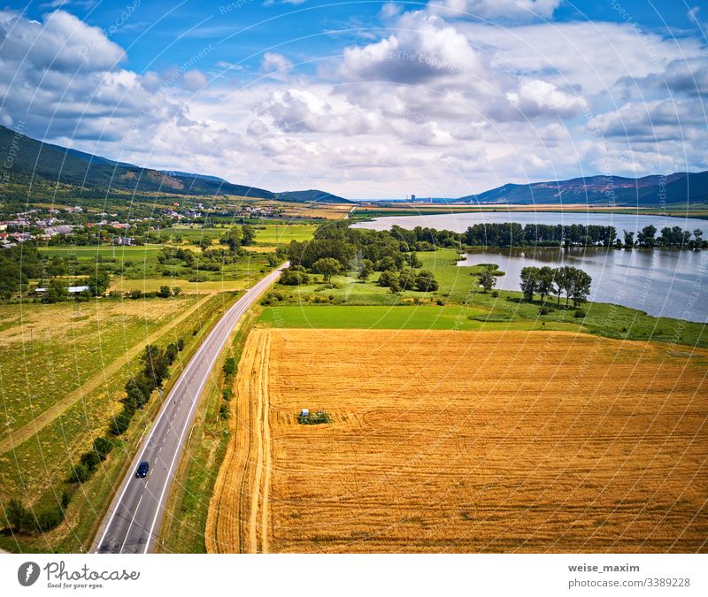 Summer landscape with fields, meadows, lake and mountains. Road on the lakeside water summer aerial Slovakia panorama alpine Tatras park hill outdoor