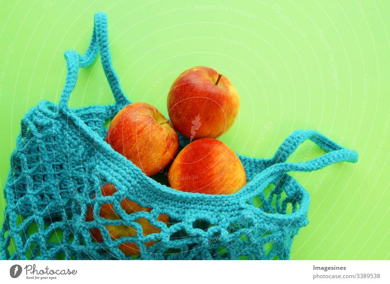 Cotton shopping net - Free of plastic. Reusable shopping bag with fruit - apples on green background. Zero waste and ecology concept. environmentally friendly buyer. top view