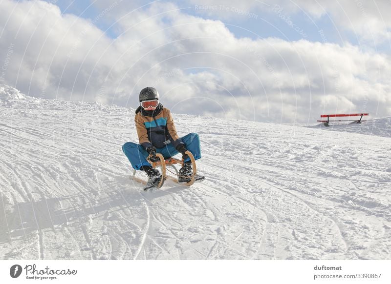Boy on sledge in snowy landscape Boy (child) Snow Sledge Sledding Sleigh sledging Funny swift Winter Ski-run Snowscape fun Cold on the outside pleasure