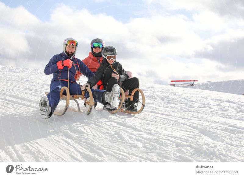 Three girls have fun sledding Girl Sports Winter sports Mountain Powder snow Downward Ski run Winter vacation Alps out Snowscape Snowcapped peak Ski-run