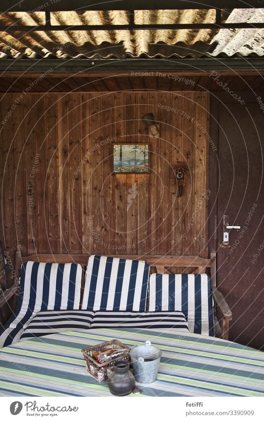 View into an abandoned allotment arbour with striped seat cushions Garden plot Cushion Striped forsake sb./sth. Deserted Interior shot Relaxation petty