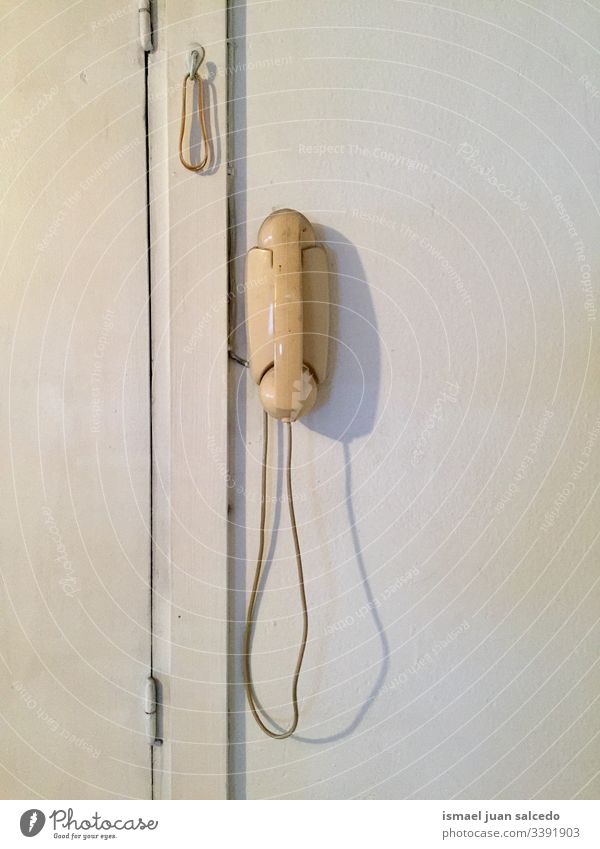 old white telephone on the white wall vintage antique antiquity dirt dirty telecommunitcation calling technology