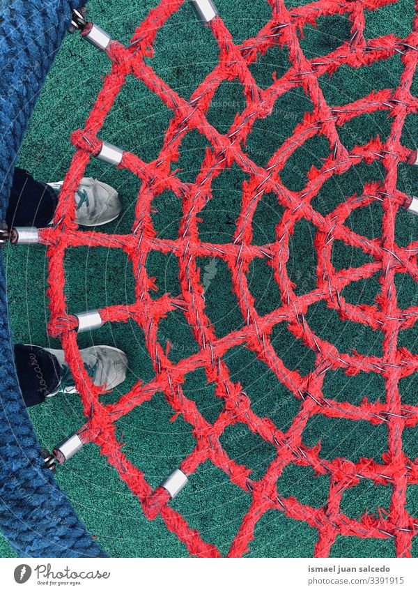 swing with red rope net playground abstract childhood playful funny sneakers feet