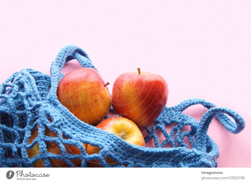 Shopping net made of cotton - Free of plastic. Reusable shopping bag with fruit - apples on pink background. Zero waste and ecology concept. environmentally friendly buyer. top view