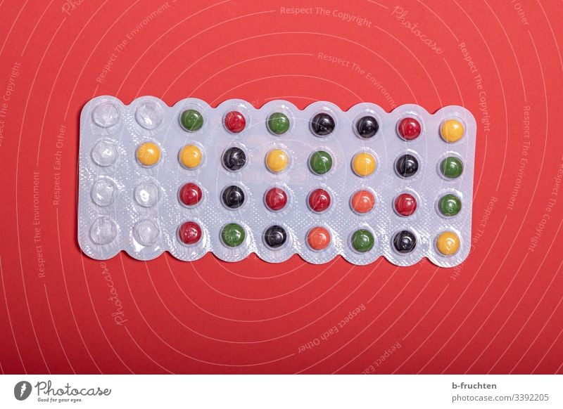 Colourful pills on red background medicine Medicine Close-up Healthy Medical treatment candy Chewing gum drug variegated Red Dragee tablets Pharmaceutics