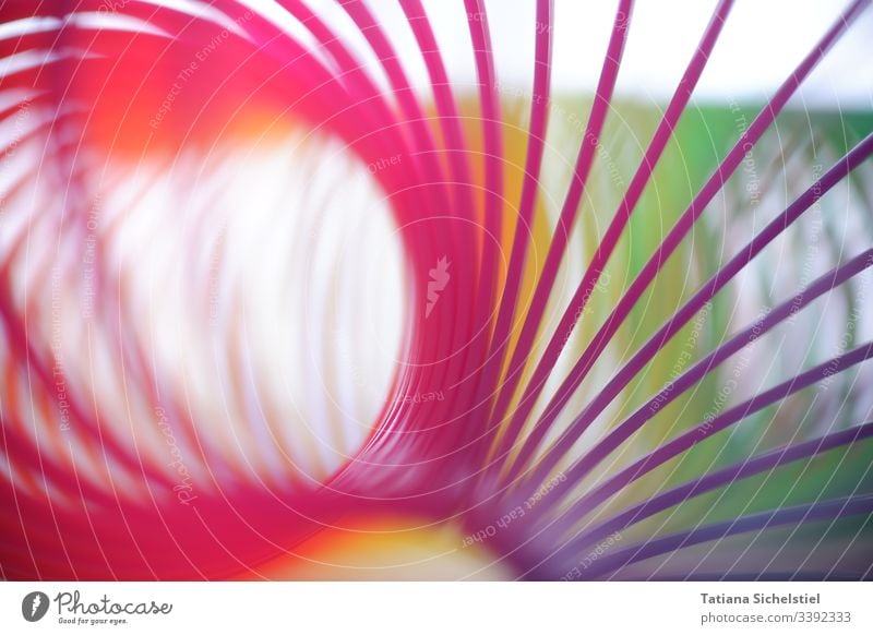Single spirals of a curved rainbow spiral / stair jumpers Toys spirally variegated Spiral spiral line Multicoloured Colour photo Close-up Blur