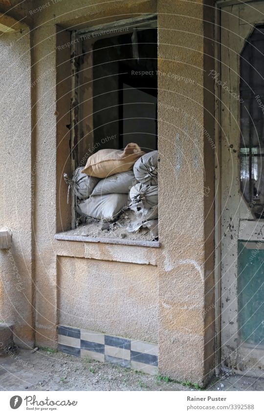 Sandbags at the window of an abandoned house in Nicosia, Cyprus North Cyprus Conflict War green line Buffer zone Window forsake sb./sth. Ruin