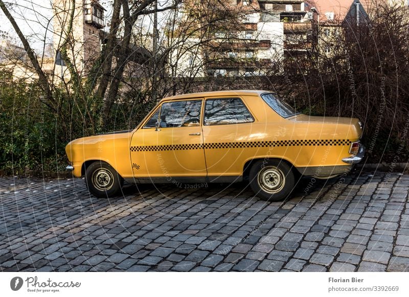 Old yellow car with taxi-route stickers on a cobblestone road Yellow Taxi Transport Means of transport Chrome Vintage car Tin rasp Cobblestones nostalgically