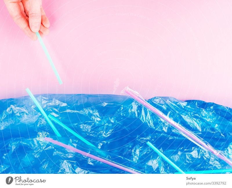 Plastic straws thrown in ocean. Pollution concept. Flat lay on pink background plastic hand pollution metaphor sea water blue flat lay symbol nature bag