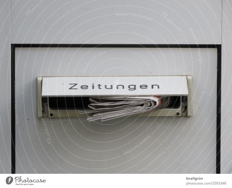 Daily newspaper in a front door letterbox with the inscription "Zeitungen steckenend Newspaper Mailbox Mailbox slot House (Residential Structure) Exterior shot