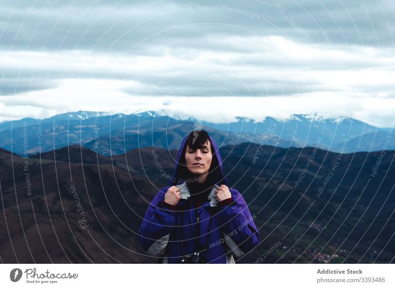 woman tourist in violet jacket with backpack with close eyes in picturesque mountain ridges while standing in Monsacro travel tourism adventure hike highland