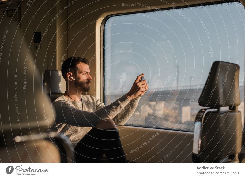 Focused young man taking photos on smartphone in metro take photo passenger photography cellphone window train male subway ride transport connection wireless