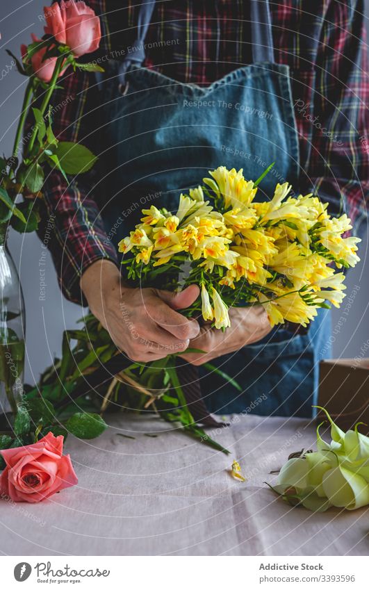 Unrecognizable female professional florist making bouquets. Blooming background owner composition beautiful creative floral craft yellow flowers job workshop
