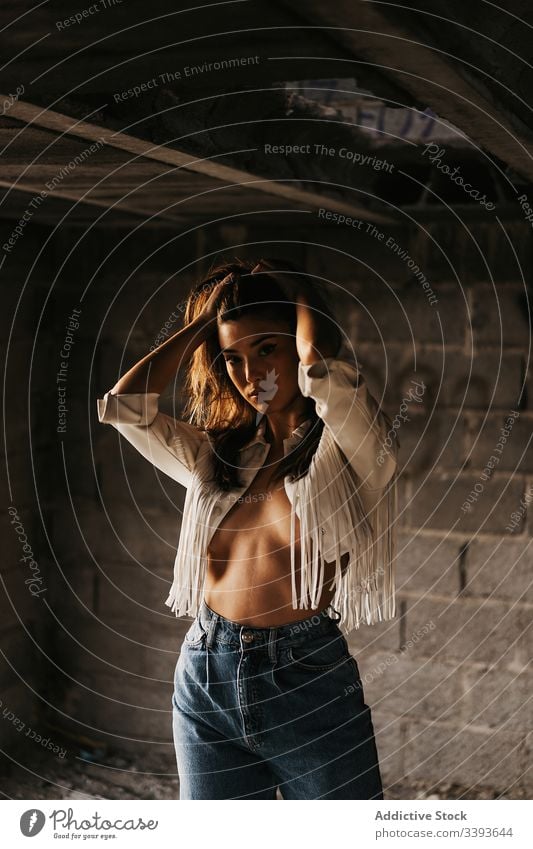 Sensitive young female model inside abandoned building woman topless seductive sensitive grunge sensual touch hair tender brunette jacket naked body appearance