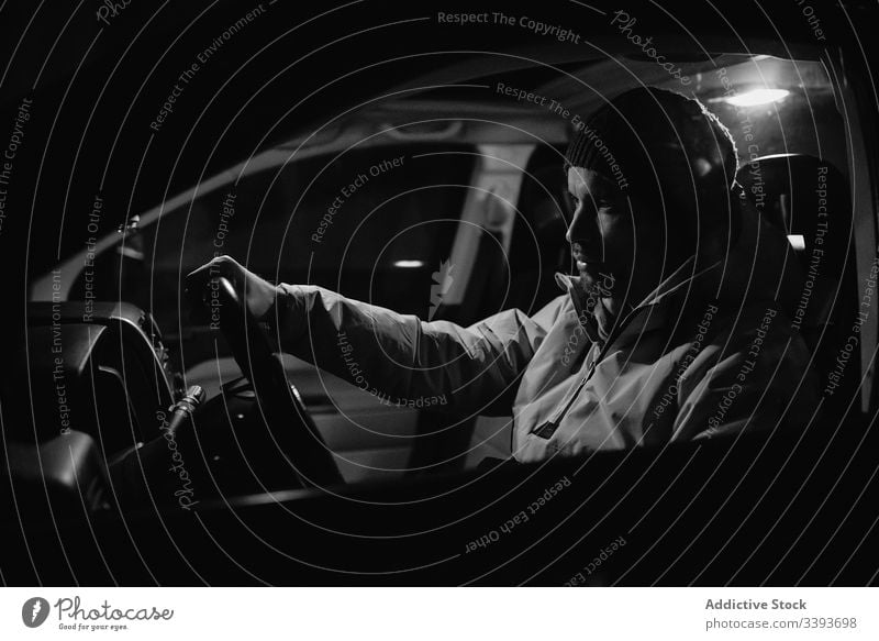 Focused man driving car at night time drive steering wheel focus ride vehicle transport travel auto journey male control road speed modern safety front light