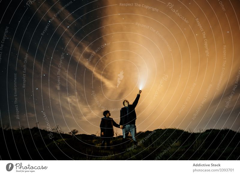 Caring father teaching son astronomy at night sky observe star dad starry show light torch holding hands male explore boy parent kid fatherhood discovery