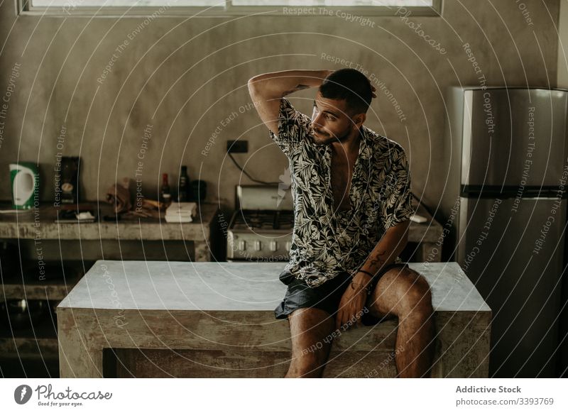Thoughtful man resting on counter in kitchen thoughtful apartment relax calm domestic morning male contemplate natural dreamy alone serious pensive young