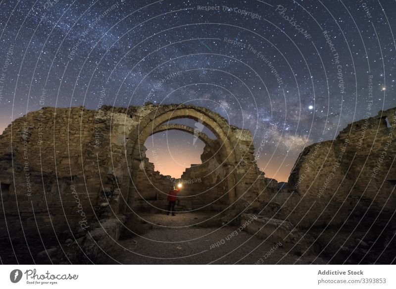 Unrecognizable tourist exploring old ruins at night explore traveler sightseeing remain ancient castle milky way starry abandoned ruined architecture medieval