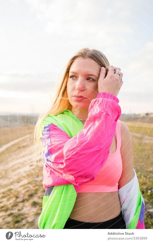 Female hipster in colorful sportswear in countryside woman nature modern blond casual summer individuality style fit cool trendy vivid young athlete female