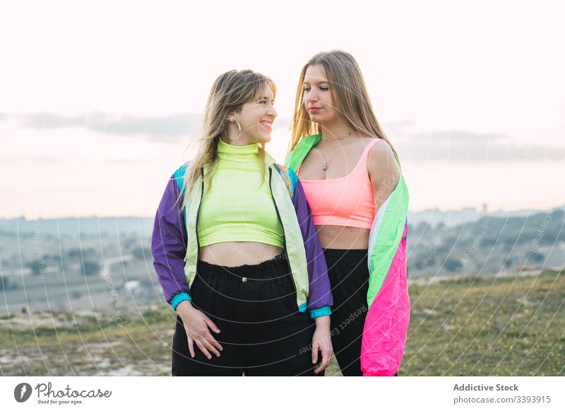 Cool modern females chatting on rural field - a Royalty Free Stock Photo  from Photocase