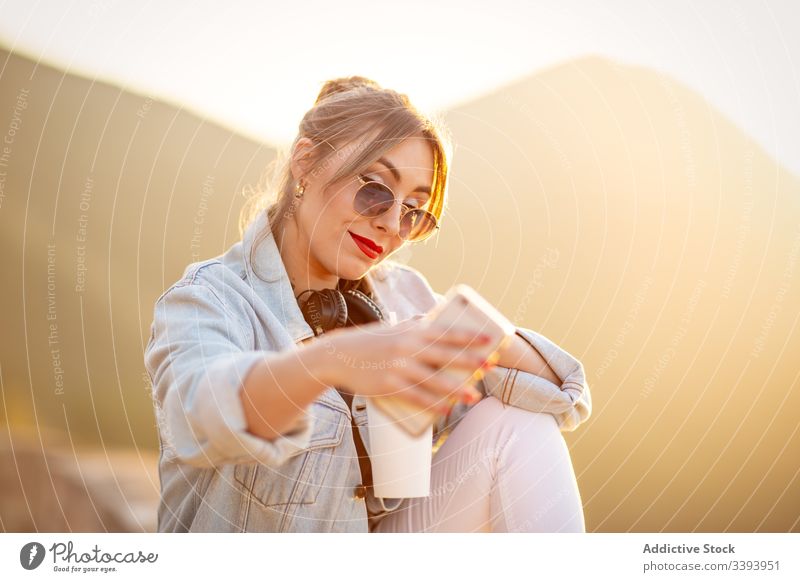 Young woman shooting selfie on smartphone during vacation mobile phone female sunglasses casual style device gadget relax happy lady rest smile trendy lifestyle