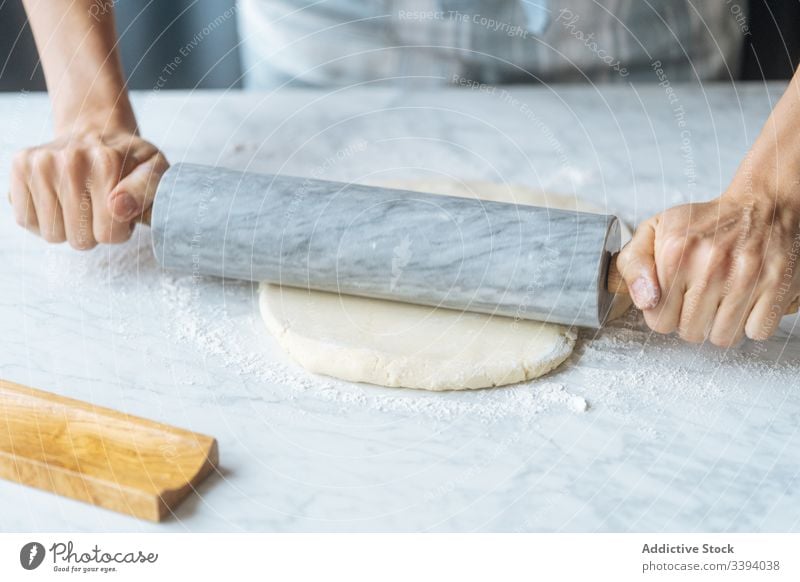 Cook rolling dough with pin on table rolling pin flour preparation cook bakery kitchen homemade culinary making apron recipe food prepare raw knead cuisine