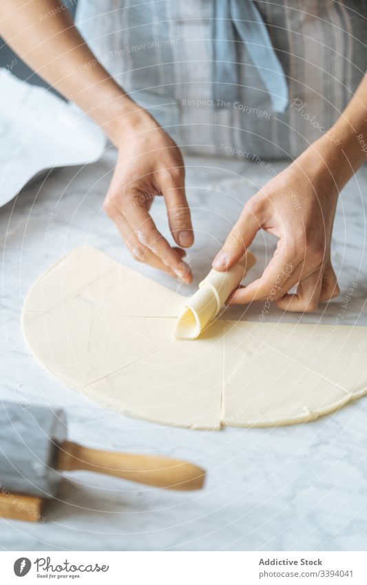 Cook twisting dough into croissant on table cook bagel flour rolling pin preparation sliced bakery homemade culinary making kitchen dessert recipe food raw