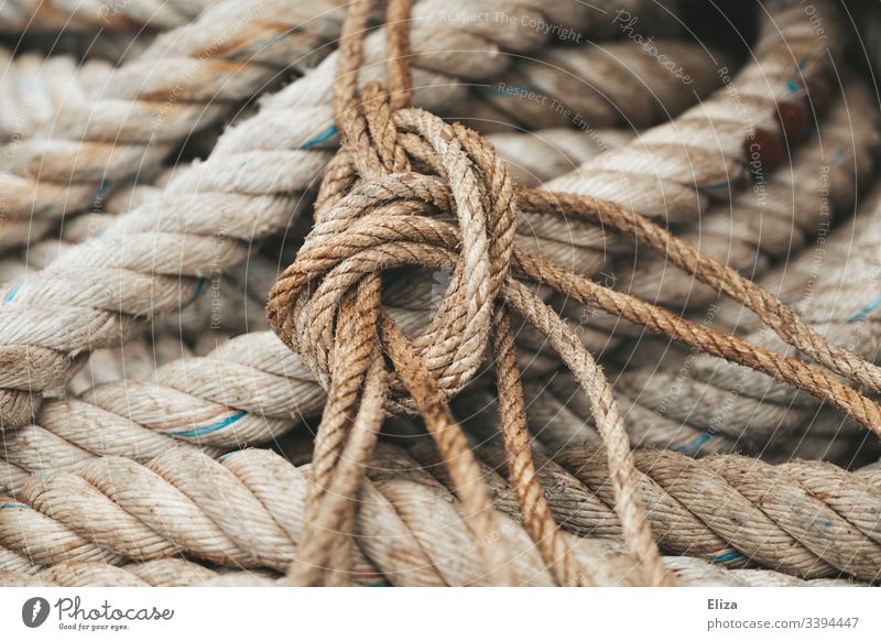 Closeup of a thick rope knot tied to a piece of metal Stock Photo